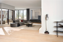 Miele cordless stick vacuum cleaner in a modern living room. 